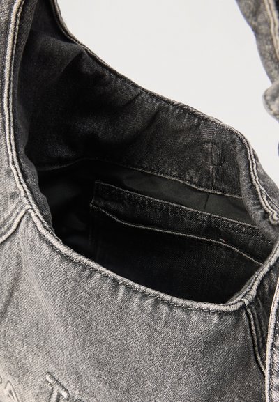 Γκρι τσάντα από τζιν με ανοιχτό πάνω μέρος που αποκαλύπτει εσωτερική επένδυση σε μαύρο χρώμα και εσωτερική τσέπη.