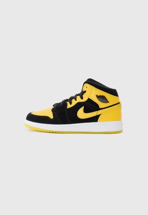 Sort og gul høj-sneaker med hvid sål, sorte snørebånd og Nike-logo på siden, vist fra venstre profil.