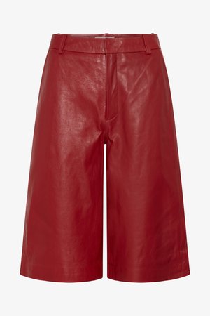 Røde skinnshorts med høyt liv og kne lengde med beltestropper og fremre søm-detalj.