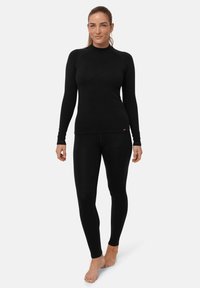 Schwarzes, langärmliges Thermoshirt mit hohem Kragen und passgenauen schwarzen Thermoleggings, aus weichem, dehnbarem Material gefertigt. Mit kleinem Logo.