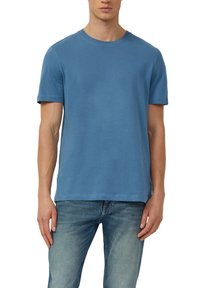 Hellblaues Baumwoll-T-Shirt mit kurzen Ärmeln, Rundhalsausschnitt und feinen Nähten. Kombiniert mit hellblauen Jeans, die eine entspannte Passform zeigen.