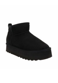 Botas de tobillo de ante negro con punta redonda, suela gruesa de plataforma negra y puño doblado en la parte superior. Textura suave con detalles de costura sutiles.