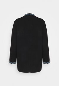 Zwarte lange mouwen jas met blauw en witte gevlochten bies op de kraag en manchetten, vanaf de achterkant tegen een witte achtergrond weergegeven.