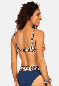 Biustonosz bikini w wielokolorowy wzór, w odcieniach pomarańczowym, granatowym i kremowym; pasujące spodenki z wysokim stanem w kolorze granatowym; gładka tekstura, regulowane ramiączka.