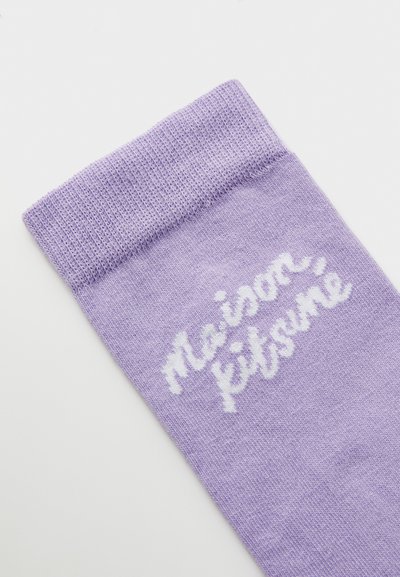 Lavender sock with a ribbed cuff. Features "Maison Kitsuné" logo in white script. Material appears soft, with a smooth texture.