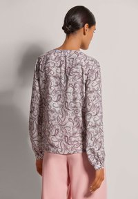 Langärmelige Bluse aus leichtem Stoff mit einem detaillierten Paisleymuster in Burgunder- und Grautönen. Die Rückansicht zeigt einen abgerundeten Halsausschnitt und eine Raffung.