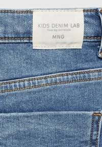 Svetlo modri denim hlače z teksturiranim zaključkom, z oranžnim šivom in belim oznakama "KIDS DENIM LAB" na pasu.
