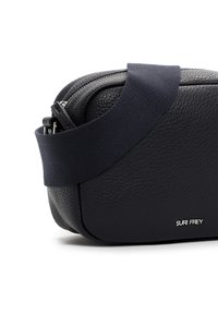 Borsa a tracolla in pelle nera con finitura testurizzata, forma arrotondata e tracolla in tessuto blu. Presenta una chiusura con zip e un dettaglio di branding in argento.
