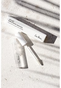 Aloe gel vippe- og brynmascara i en klar tube med hvit hette, ledsaget av en hvit eske med svart tekst og merkevare.