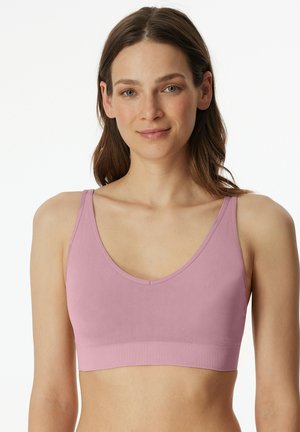 Pink wireless bralette with a smooth texture, wide straps, and a rounded neckline. Seamless design with a stretchy, soft fabric.