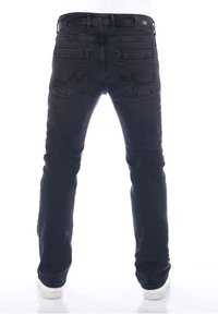Vaqueros de denim negro con corte ajustado, cinco bolsillos y detalles de costura sutiles. Cuenta con un parche de logo en la cinturilla y dobladillos remangados.
