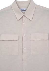 Camicia button-up beige chiaro con colletto, due tasche sul petto e bottoni bianchi. Realizzata in un tessuto testurizzato, presenta un design a vestibilità rilassata.