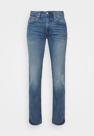 Jeans de denim azul con un diseño de pierna recta, que presentan detalles desgastados, un estilo de cinco bolsillos y un cierre de botón metálico en la cinturilla.