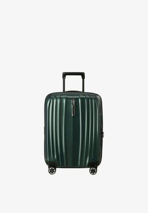 Valise rigide vert foncé avec des rainures verticales, quatre roues pivotantes et une poignée noire rétractable.