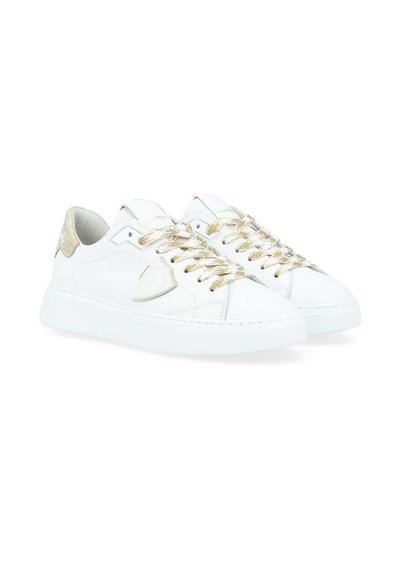 Baskets en cuir blanc avec des accents dorés, des lacets texturés et une semelle blanche rembourrée. Présente un logo triangulaire sur le côté.