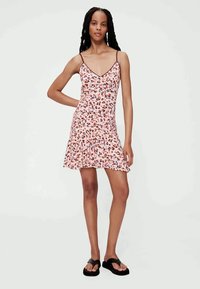 Jurkje met bloemenprint in het roze met dunne bandjes, een uitlopende zoom en een aansluitend lijfje. Heeft meerkleurige vlekken. Gladde stof, casual ontwerp.