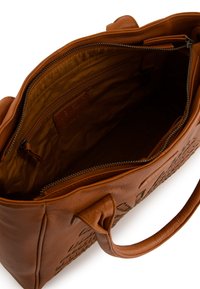Sac en cuir marron avec un extérieur texturé, fermeture zippée en haut et poches intérieures. Doublure douce et poignées solides pour un transport facile.