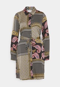 Sukienka koszulowa z długim rękawem, w miks wzorów w kolorze czarnym, złotym i różowym. Posiada kołnierz, zapięcie na guziki oraz związany pas.