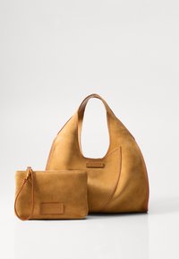 Sac à main en suede tan avec une forme courbée large et une poignée plus courte, accompagné d'une pochette zippée assortie avec une sangle de poignet.