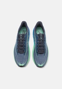 Zapatillas deportivas azul marino con suelas de acento verde, parte superior de malla, diseño perforado y cordones negros, adecuadas para correr.