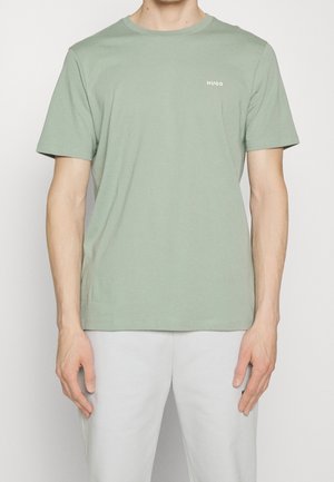 Lys grøn bomulds t-shirt med korte ærmer, rund halsudskæring og lille hvid "HUGO" logo på venstre bryst.