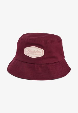 Maroon bucket hat made of cotton with a wide brim and an embroidered logo patch in light pink on the front. Smooth texture.