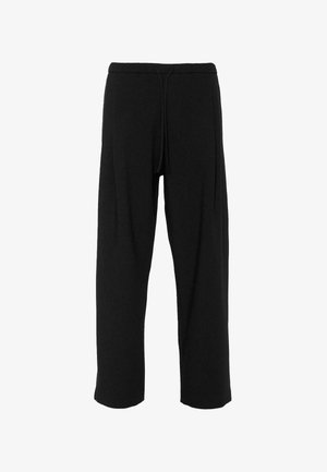 Melni sporta bikses ar brīvu piegriezumu, izgatavotas no mīksta auduma. Tam ir elastīga josta ar stringu un nav redzamu rakstu vai akcentu.