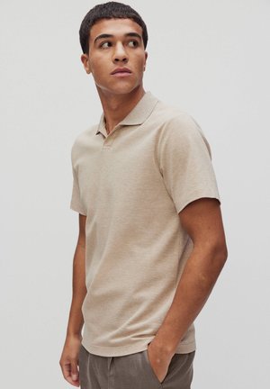 Beige lyhyet hihat polo-paita, joka on valmistettu pehmeästä kankaasta ja jossa on klassinen kaulus. Se on rentoa istuvuutta ja siinä on minimaalinen ompelu.