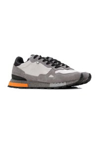 Zapatillas de ante y tela en gris con detalles en negro, suela intermedia texturizada, detalle en naranja en el talón y cordones negros. Adecuadas para uso casual.