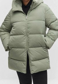 Gepolsterte Jacke in Hellgrün mit Kapuze, Reißverschluss vorne und gestepptem Design mit horizontalen Nähten. Das Material wirkt weich und glatt.