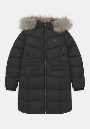Manteau d'hiver long matelassé noir avec fermeture éclair à l'avant, deux poches avant et une capuche bordée de fausse fourrure marron clair.