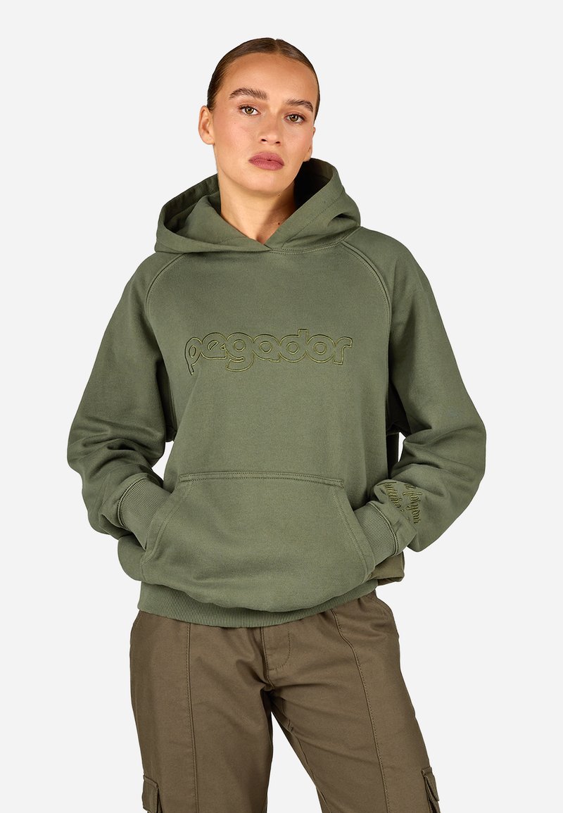 Πράσινο φούτερ με καγκουρό τσέπη και ραμμένα μανίκια. Διαθέτει ανάγλυφο λογότυπο μπροστά. Λείο βαμβακερό ύφασμα. Συνδυάζεται με καφέ παντελόνι.