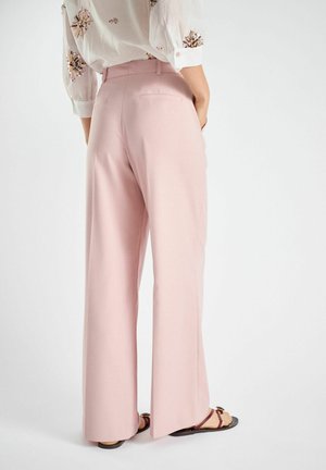 Pale pink wide-leg trousers with a smooth texture, featuring two back pockets and a high waist design, paired with brown strappy sandals.