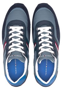 Chaussures de sport bleu marine et bleu clair avec lacets blancs, accents en daim et dessus texturé ; présentent un logo sur la languette et une semelle intérieure bleue.