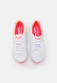 Zapatillas deportivas blancas con parte superior de malla, con un interior rosa, cordones y una suela de goma flexible con un acento rosa en el talón.