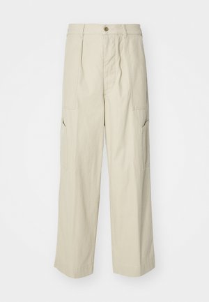 Μπεζ cargo παντελόνια με άνετη εφαρμογή, δύο μπροστινές τσέπες και ελαφρώς υφασμάτινη υφή. Διαθέτει κλείσιμο με κουμπί και σχέδιο με φαρδιά πόδια.