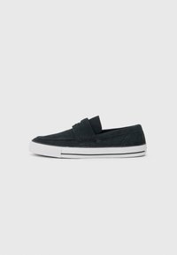 Mørkeblå ruskind slip-on sko med lav profil, hvide gummisåler og detajler med kontrastsyning. Flad, rund tå-design.