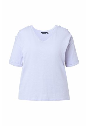 Biała biała koszulka z krótkim rękawem i dekoltem w serek, ozdobiona guzikami przy szwach ramion, prezentowana na jednolitym tle.