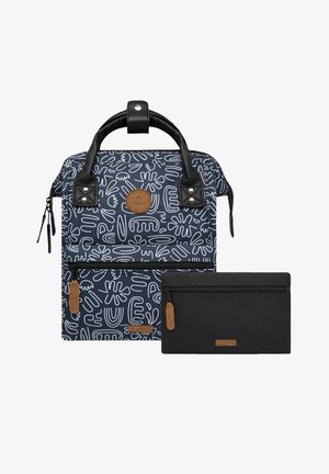 Navy patterned backpack with black leather handles, featuring a front zip pocket and a black zip pouch, both with tan leather accents.