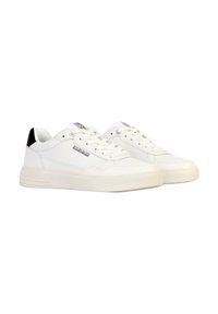 Sneakers bianchi realizzati in pelle liscia con un design minimalista, caratterizzati da un accento nero sul tallone e una suola piatta in gomma. Chiusura con lacci.