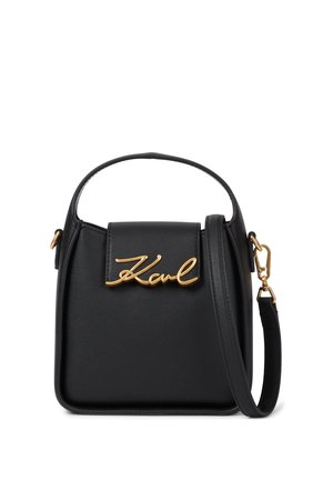 Sac à main en cuir noir avec poignée supérieure, bandoulière amovible et détail signature doré "Karl" sur le rabat avant.