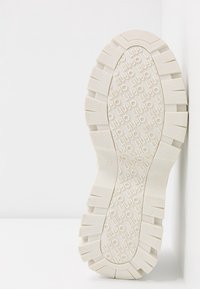 Semelle de chaussure en caoutchouc blanc avec surface texturée, présentant des logos "LIU JO" en relief et un motif de bande de roulement important. Taille indiquée : 37.