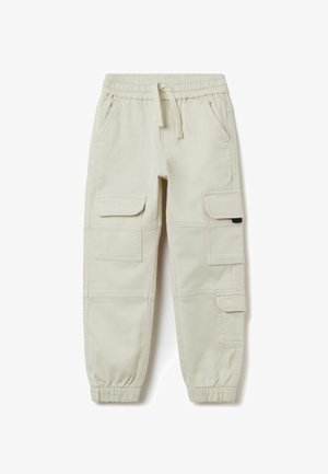 Pantalones cargo en color beige con cintura elástica y cordón. Presenta múltiples bolsillos laterales y puños ajustados. Fabricados con un tejido resistente.
