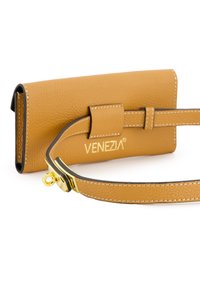 Venezia tan leren accessoireset met een gladde textuur, een veilige flapsluiting en een afneembare schouderband met gouden hardware accenten.