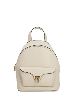 Small beige leather backpack with a front pocket secured by a gold clasp and a top handle against a white background.