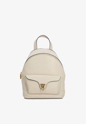 Small beige leather backpack with a front pocket secured by a gold clasp and a top handle against a white background.