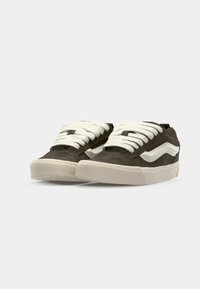 Dark green suede sneakers with white laces and a white side stripe. Features a textured rubber sole for grip and durability.