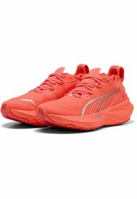 Des chaussures de course en corail brillant avec une tige en maille texturée, une semelle rembourrée et des accents argentés. Comprend une languette au talon et un système de laçage.