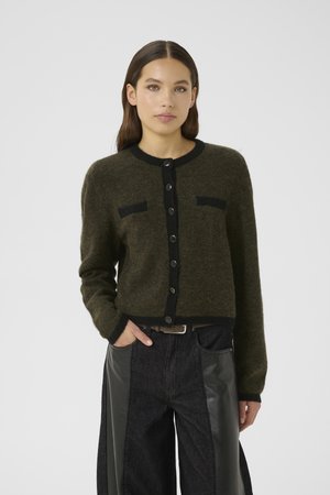 Olivenfarget cardigan laget av et mykt, teksturert materiale, med svart kant og knapper, og to svarte lommeakenter.