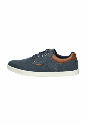 Zapatillas de lona azul oscuro con detalles en cuero marrón. Cuentan con puntera redondeada, diseño de seis ojales para los cordones y suela de goma blanca.